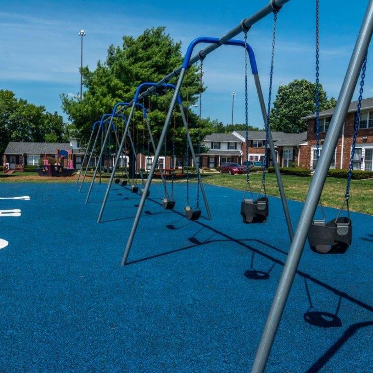 Metal swingset on blue rubber surface