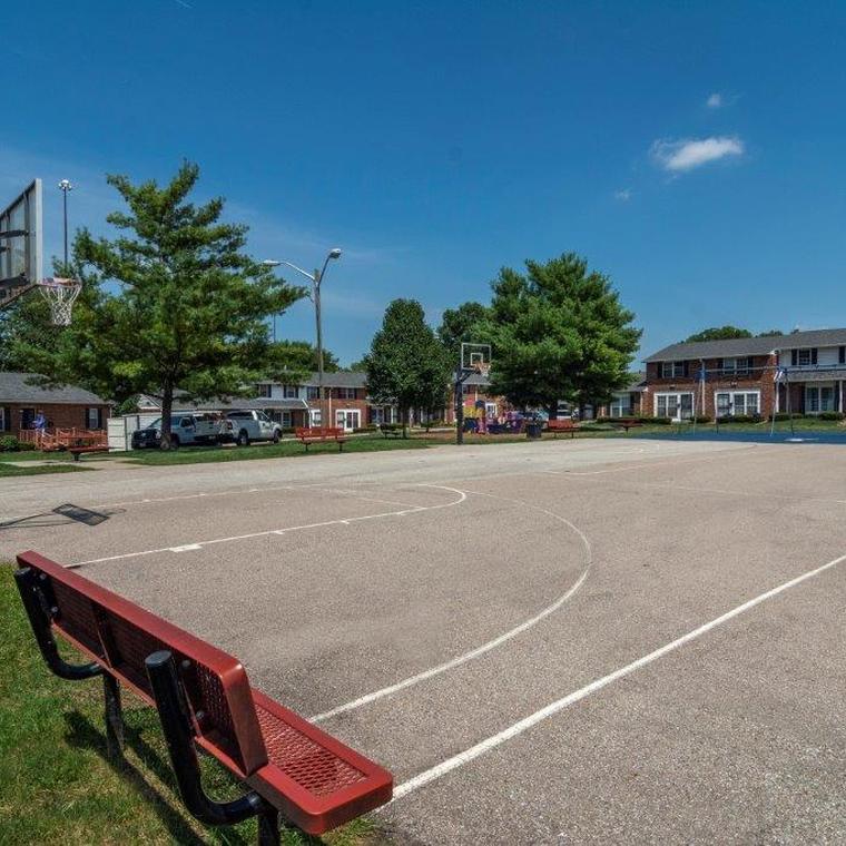 Basket ball court on asphalt with red bench and view of the apartment exterior