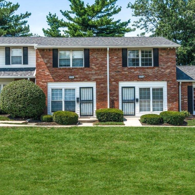 Brick apartment exterior with white trim, black shudders and black metal storm doors